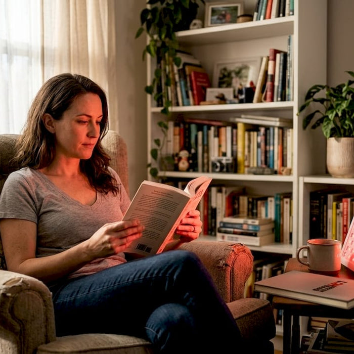 Woman reading during home red light therapy session