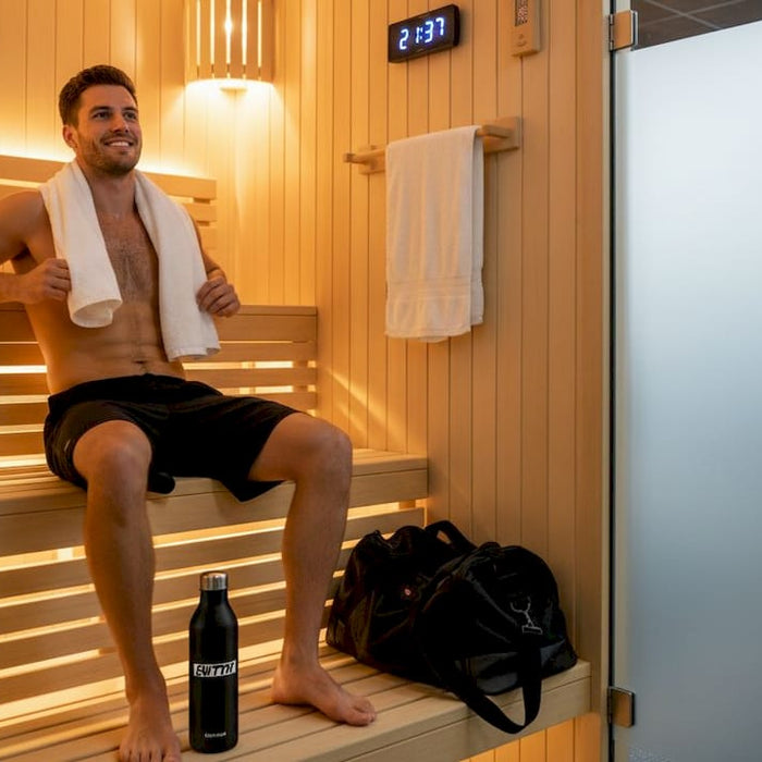 Athlete resting on bench inside sauna room